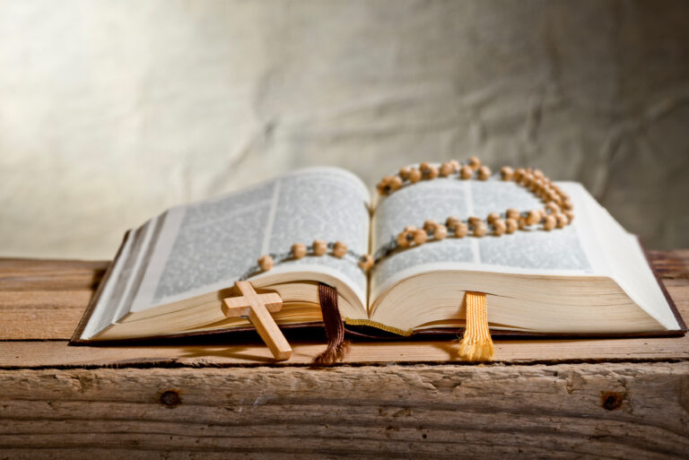 Rosary With Old Bible on the Desk